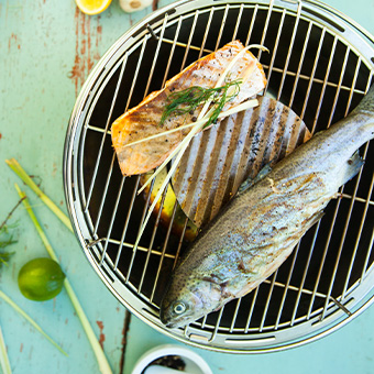 instagram-3Uvr4IUpGgQB1I Gegrillter Lachs und eine ganze Forelle auf einem kleinen Tischgrill, Draufsicht