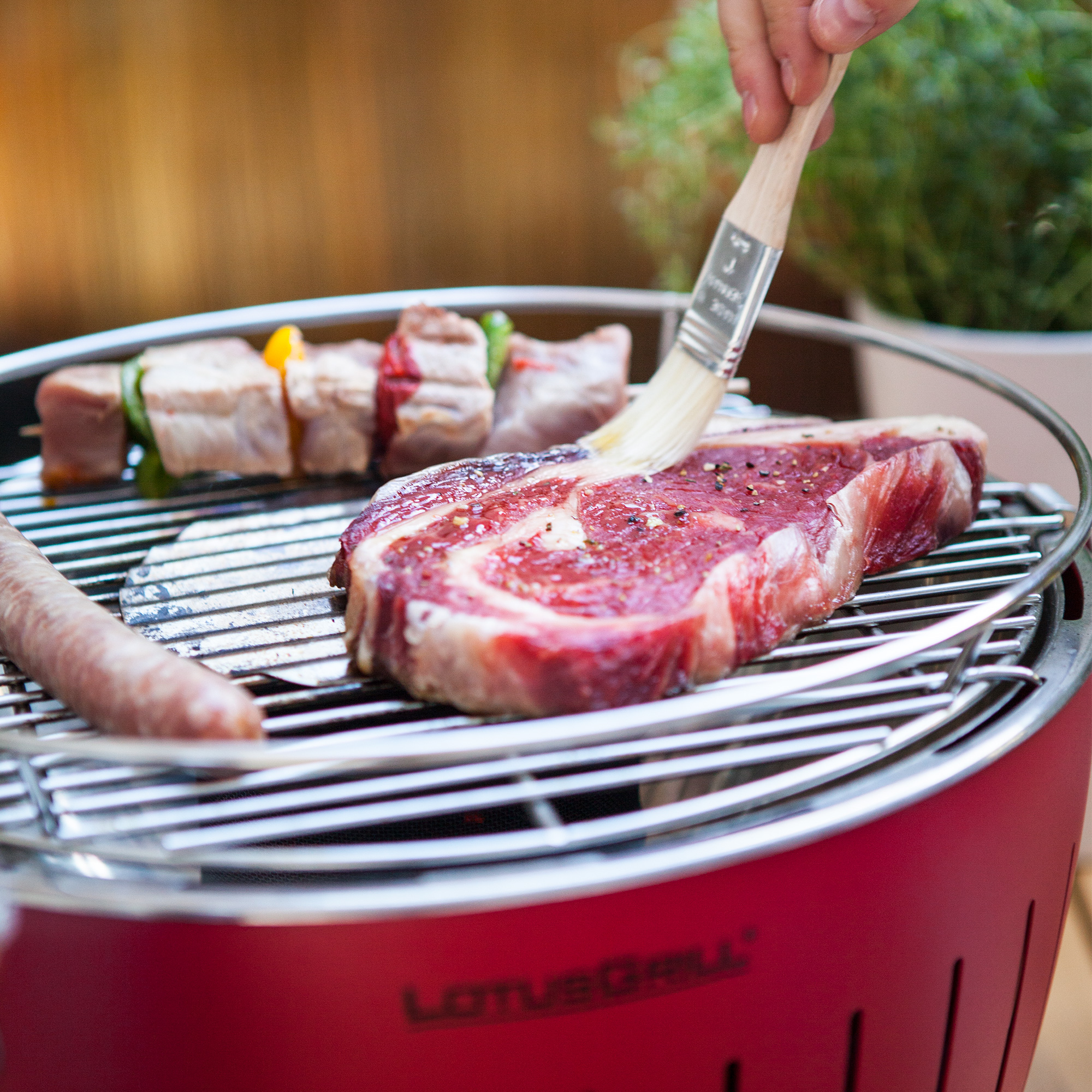 instagram-4 Fleisch wird auf einem roten LotusGrill Classic gegrillt, Nahaufnahme